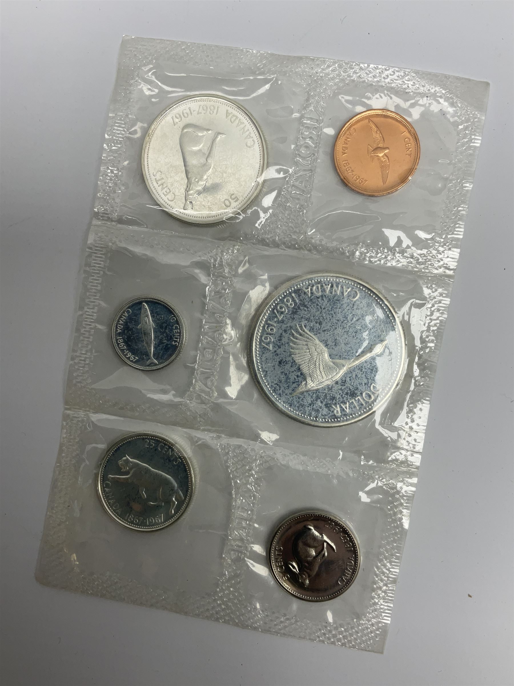 Mostly Canadian coins including 1967 six coin set, various Canadian 50 cent coins, various nickels, Royal Canadian Mint 1990 specimen coin set in blue folder with outer sleeve, various Canadian dollars etc, in folders and loose