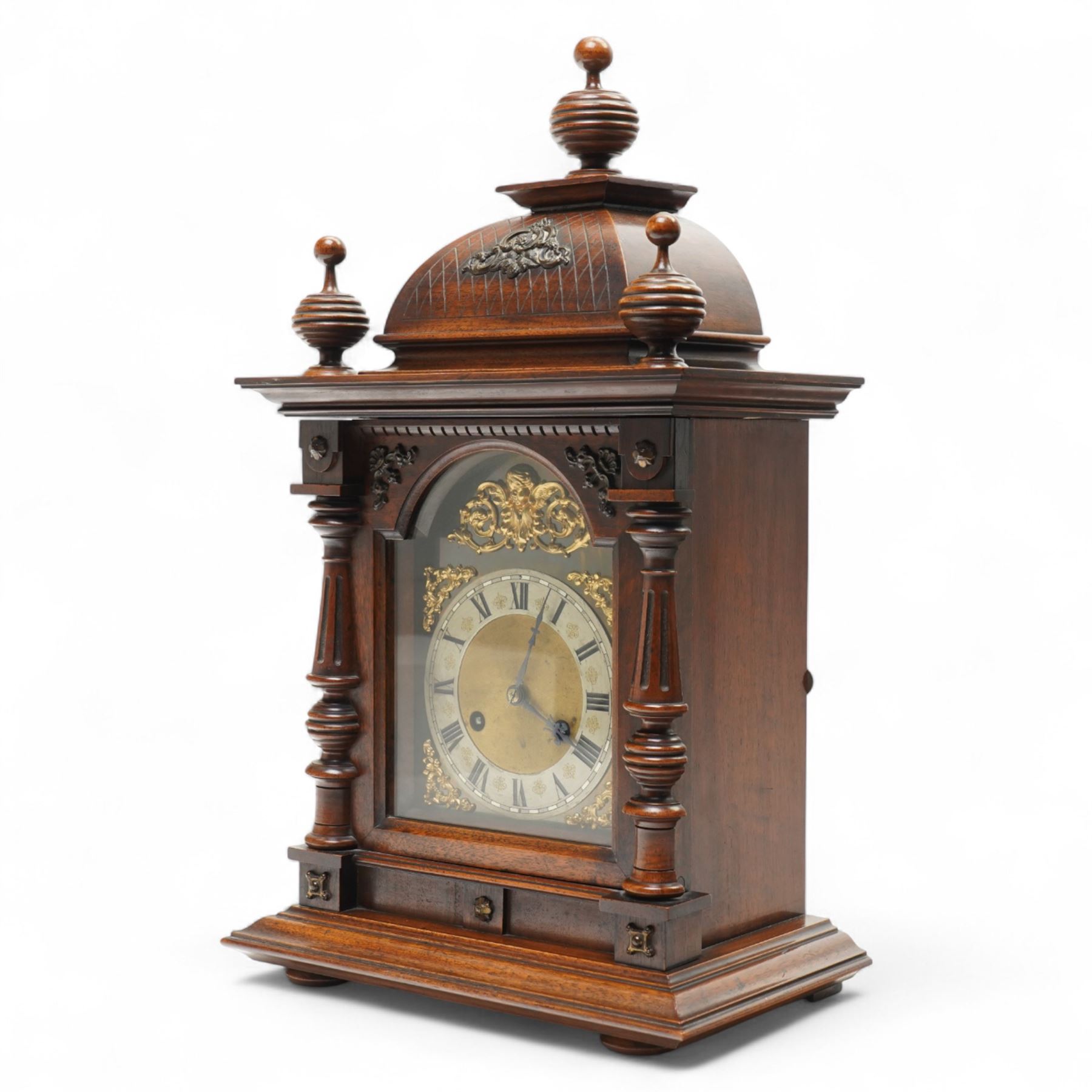 German-Junghans late 19th century oak cased mantle clock, with a domed pediment and three matching turned finials, break arch door beneath with attached turned and tapered pilasters, brass dial with cast spandrels, matted dial centre, steel hands and silvered chapter ring with Roman numerals, two train movement striking the hours and half-hours on a coiled gong. With pendulum and key.