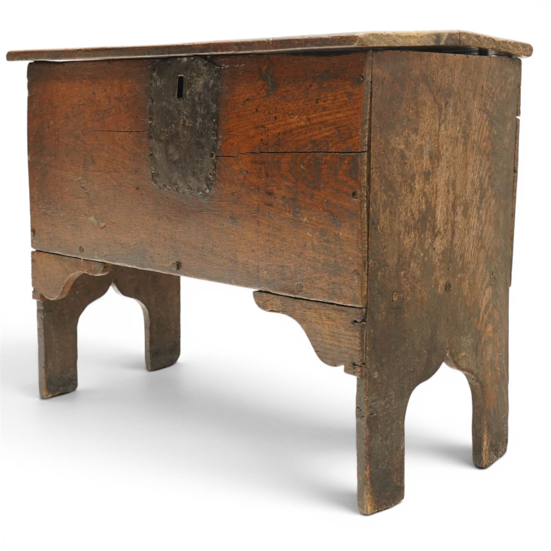 Small 17th century six plank oak coffer, figured top with iron pintle type hinges,  pegged boarded sides, large lock plate with rivets, plank ends continuing down as supports