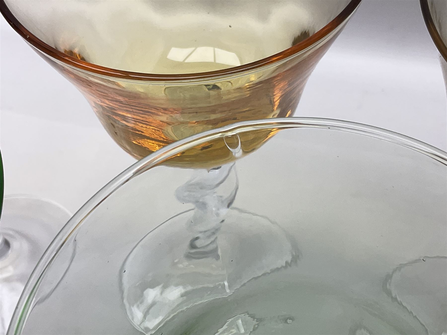 Ten coloured Adriana wine glasses by Abigails, to include blue, green, pink and yellow examples, each with part faceted bowl and twist stems, together with two similar orange examples with pulled stems, H24cm
