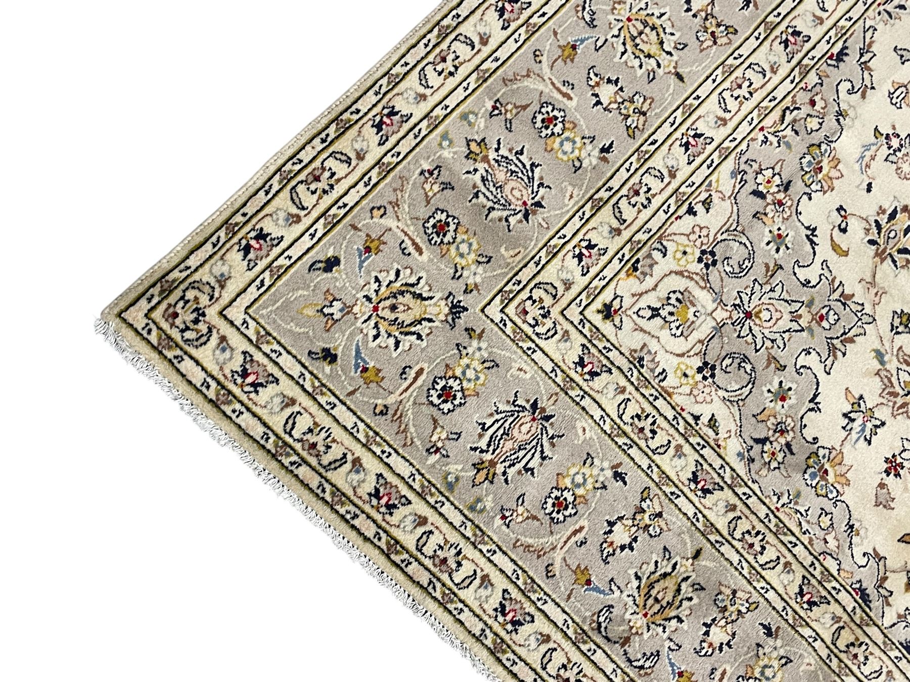 Persian Kashan ivory ground carpet, floral central medallion surrounded by trailing leafy branches and palmettes, floral pattern spandrels and matching border, within guard stripes
