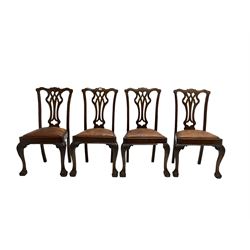 Set four George III Chippendale-style mahogany dining chairs, shaped serpentine cresting rail with pierced and splat back, drop-in sprung seat upholstered in tan leather, raised on scroll and foliate carved cabriole supports with ball and claw feet