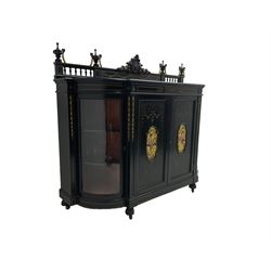 Victorian ebonised credenza side cabinet, raised balustrade back with urn finials and a central carved cartouche, carved and gilded with floral garland decoration, central doors with gilt panels painted with figures sitting over a lake enclosing two shelves, flanked by applied bellflower detail and glazed bow-front side doors, raised on ring turned feet with castors