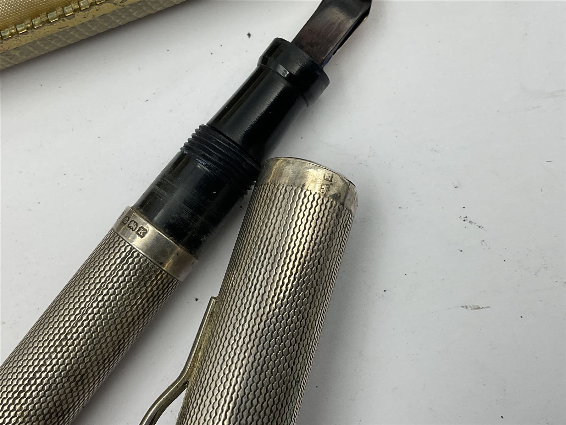 Three parker fountain pens, one example with 14ct gold plated cap and personal engraving, in Parker 51 box, together with a silver Sampson Mordan Everpoint propelling pencil with personal engraving and a silver cased fountain pen with 14ct gold nib and a souvenir bronze Dollfus-Mieg medallion, awarded to John G Sedorski, in fitted case 