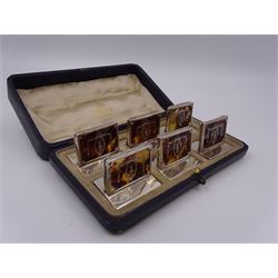 Set of six early 20th century silver mounted tortoiseshell place card holders by Asprey, the rectangular silver reed and ribbon frame bordering a central tortoiseshell panel inlaid with a silver floral motif, upon an oblong foot, hallmarked Asprey & Co Ltd, London 1913, H3cm, contained within a tooled leather fitted case with velvet and silk lined interior 