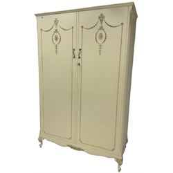 French classic design cream painted double wardrobe, the doors decorated with gilt and cream applied urn motifs with extending bell-flower festoons and ribbon twists, enclosing shelf and hanging rail, shaped apron on acanthus cabriole feet