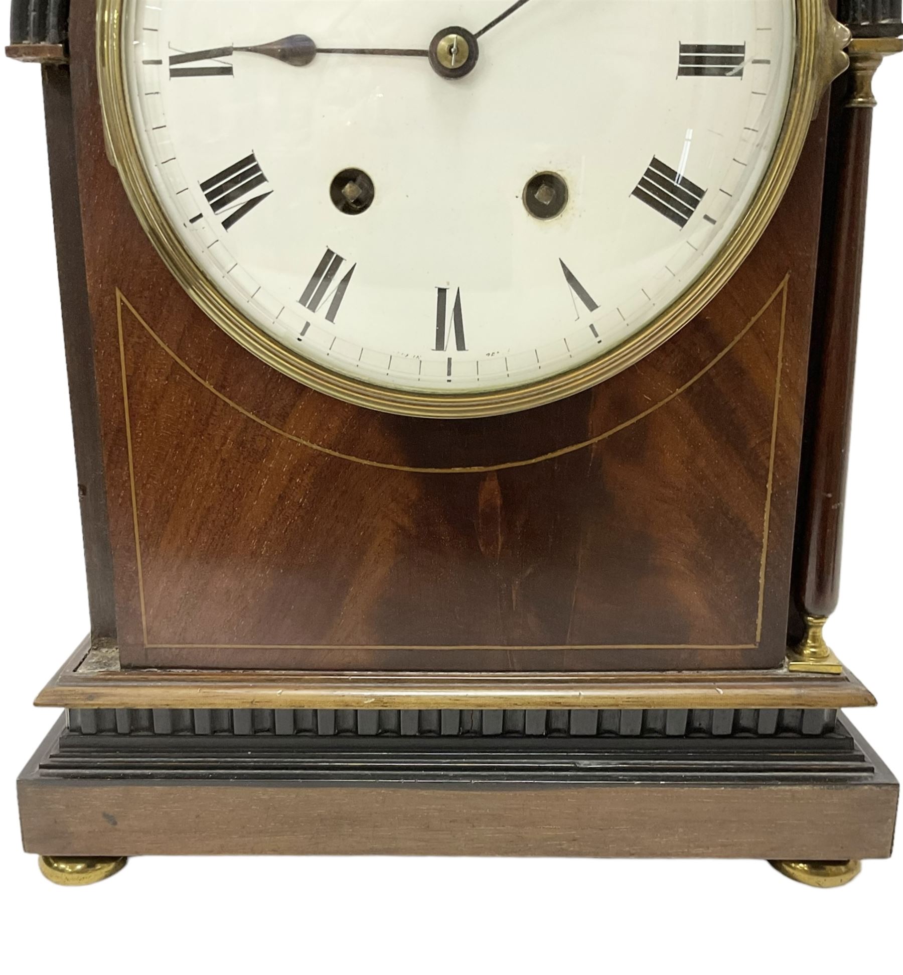 Manoah Rhodes & Son of Bradford, - Edwardian mahogany domed top mantle clock with a French 8-day movement striking the hours and half hours on coiled gong, case with inlaid stringing and raised on brass button feet, convex enamel dial with Roman numerals and steel spade hands. With pendulum and key.