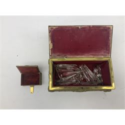 Collection of victorian and later brass desk accessories, to include a letter holder with cherub design, ink well of square form with hinged lid, brass table bell, brass casket with relief decoration, etc  