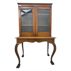 Late 19th century oak display cabinet, rectangular form with a pair of glazed doors enclosing shelves, raised on cabriole supports with carved detailing ending in claw feet