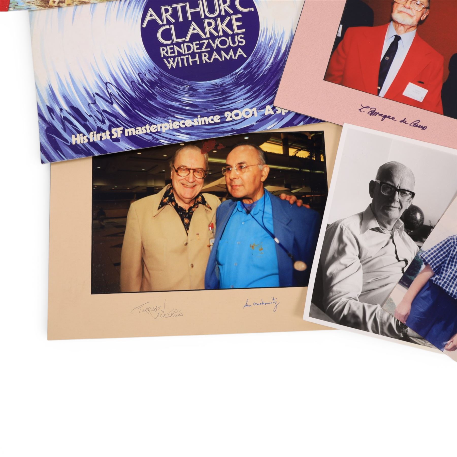 Collection of ephemera relating to Arthur C Clarke, including colour photograph of Arthur with author Joe Green, Jay Kubica and astronaut Chris Hadfield at NASA Kennedy Space Centre, Kennedy Space Centre pennant flag, colour photographs of authors Sam Moskowitz with Forrest Ackerman and L. Sprague de Camp with Robert Bloch, all signed below by the authors, a black and white photograph of Arthur for his 13-Part ITV series 'Arthur C Clarke's Mysterious World', Pan Books cardboard advertisement for Rendezvous with Rama and an Evening Standard poster for The Other Side of the Sky

Notes: This item is from the private collection of Arthur C. Clarke's brother.