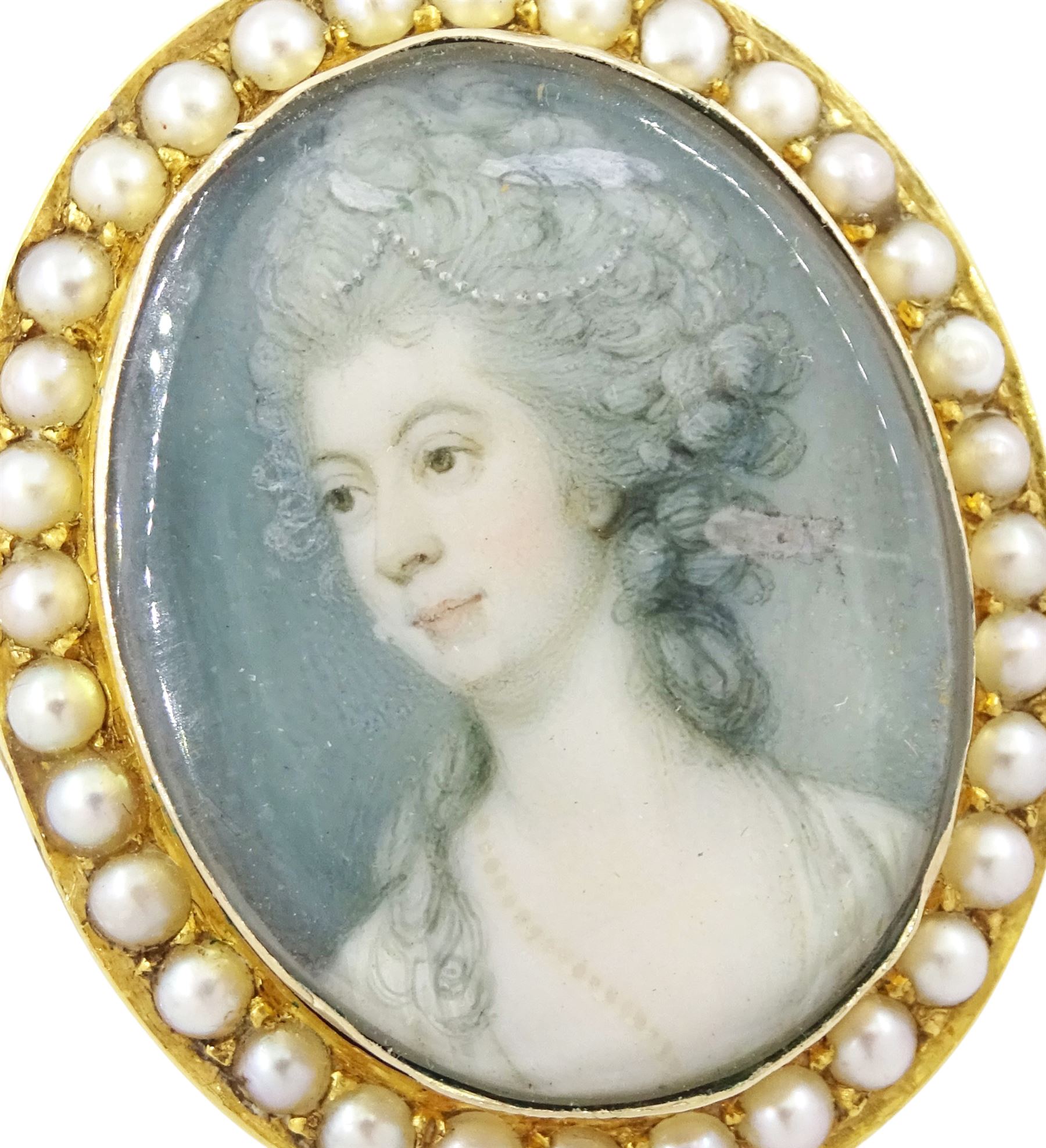 19th century 9ct gold seed pearl brooch/ pendant, set with an oval miniature of a woman, on ivory, under a glazed panel, with a seed pearl surround. This lot has been registered for sale under Section 10 of the APHA Ivory Act