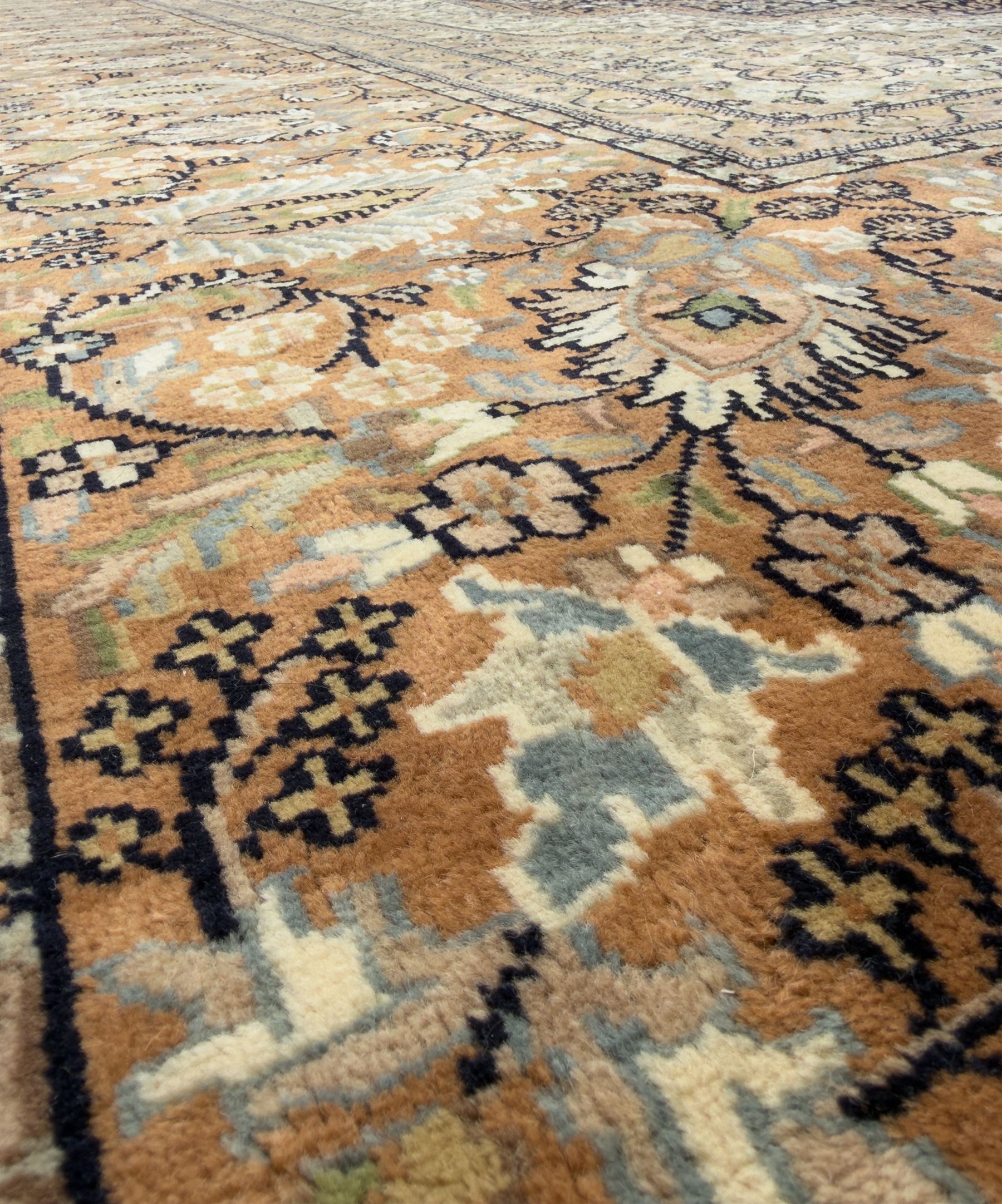 Large Persian indigo ground rug, the busy field decorated with trailing branches and flower heads, peach border decorated with palmettes -