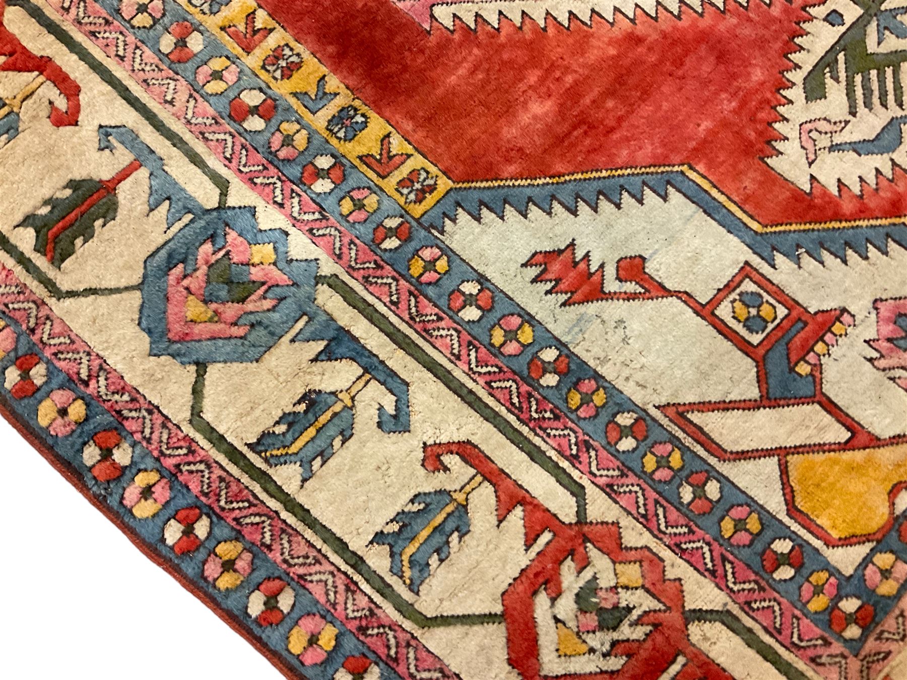 Anatolian Turkish ivory ground carpet, the central geometric pole medallion within an amber field, the guarded border decorated with stylised plant motifs surrounded by bands of repeating flower heads