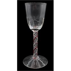 18th century drinking glass, probably Continental, the rounded funnel bowl with moulded part fluting upon a colour twist stem with alternating red and white spirals surrounding a white fine spiral gauze, and conical foot, H13.5cm