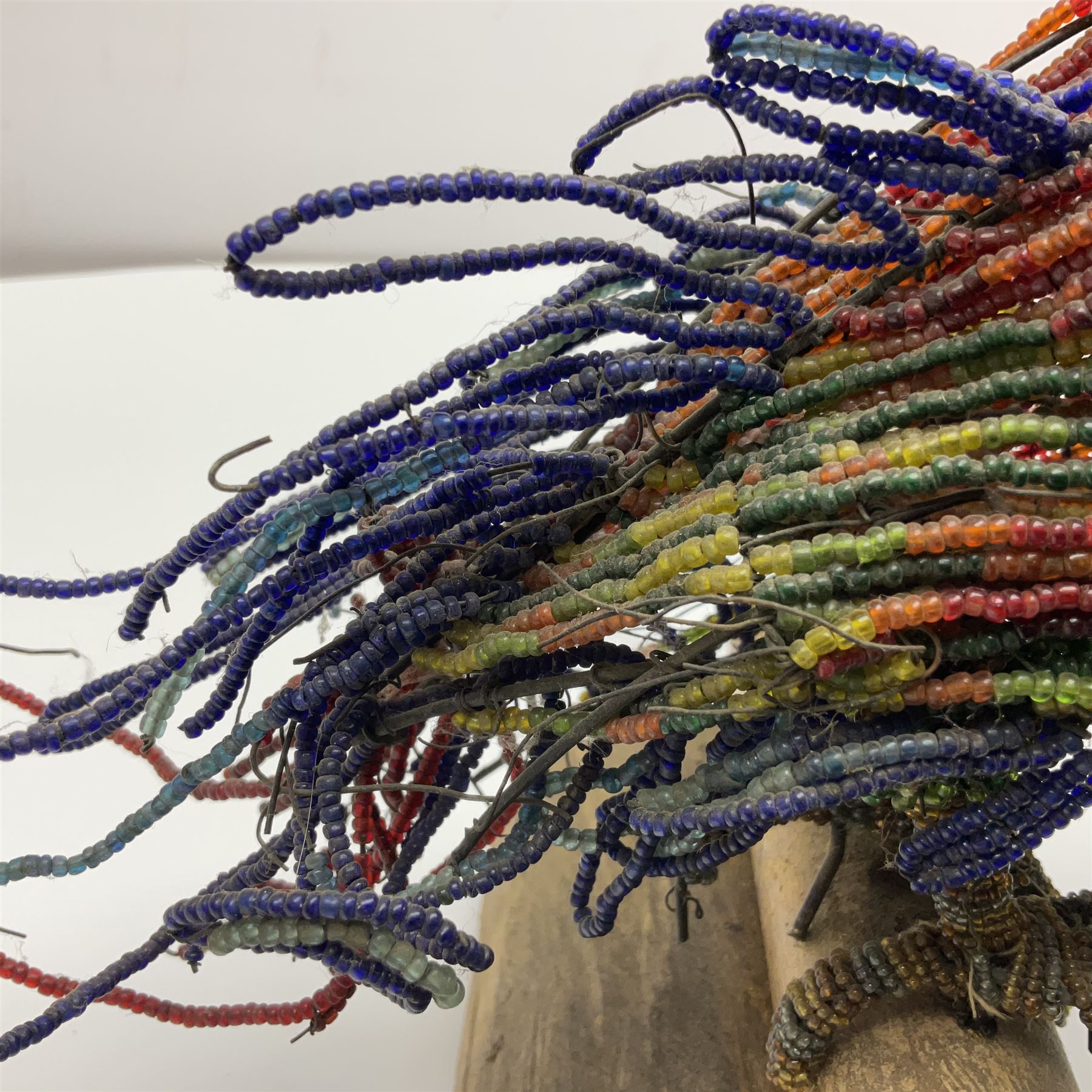 Victorian bead and wire model of a parrot, of polychrome beads, with glass eyes, on a wooden base, H24cm
