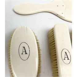 Early 20th century five piece ivory dressing table set, comprising handheld mirror, two hairbrushes and two clothes brushes, each initialled with the letter A. 