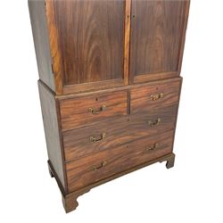 George III mahogany Gentleman's linen press, the projecting cornice over two panelled cupboard doors enclosing three sliding trays, the base fitted with two short over three long graduating cock-beaded drawers, lower moulded edge over bracket feet