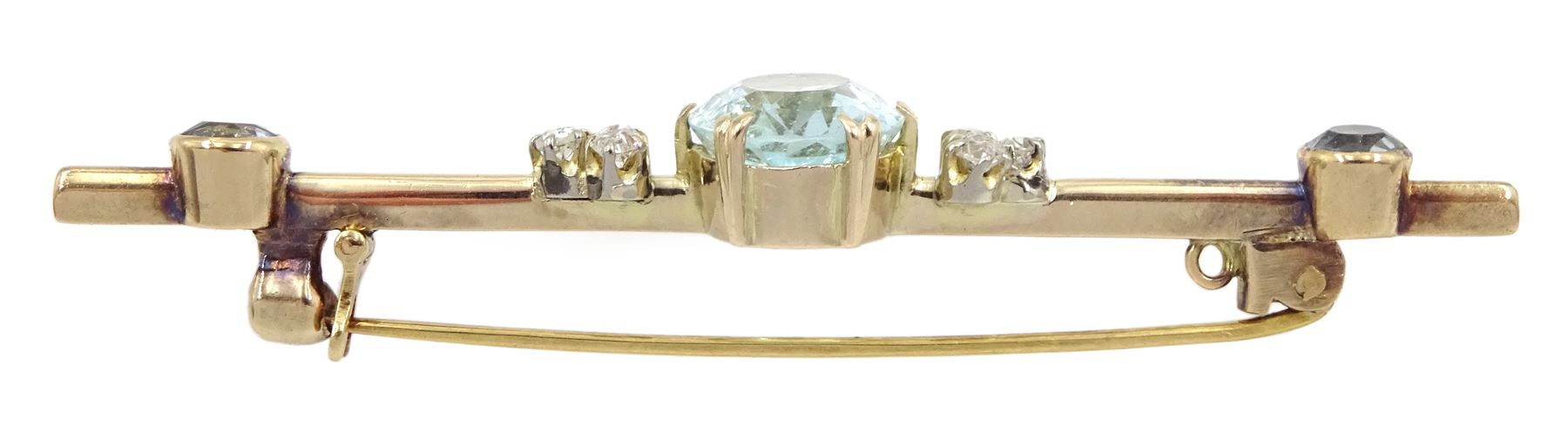 Early 20th century gold aquamarine and diamond brooch, the oval central aquamarine of approx 3.10 carat, set with three old cut diamonds either side and two aquamarines to each end