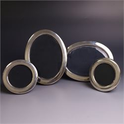 Four late 20th century silver mounted photograph frames, comprising two oval frames and pa...