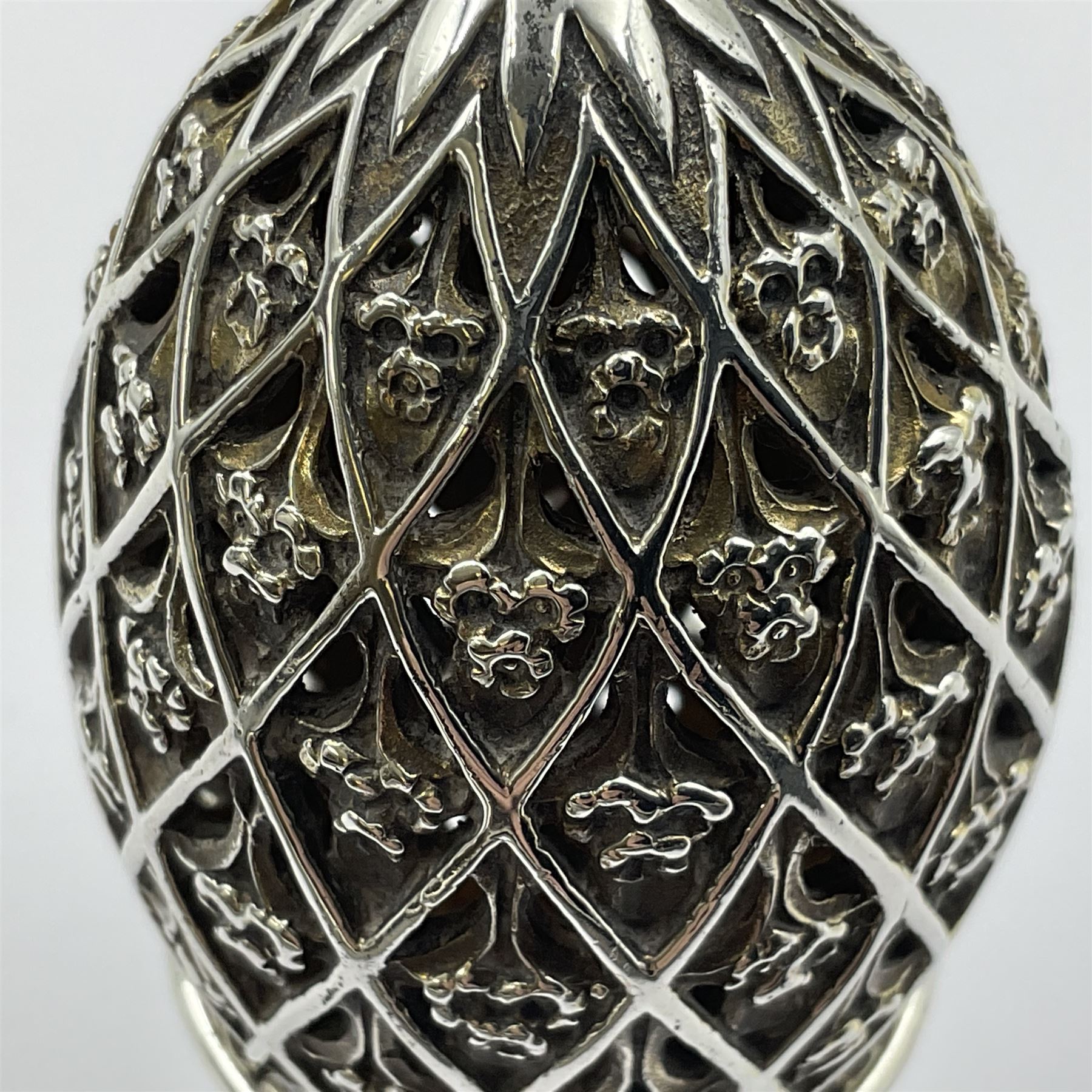 Modern silver limited edition Easter egg, no. 70/500, the openwork lattice body decorated with gilded panels of flower heads, opening to reveal a gilt interior, upon silver stand with three scrolling pad feet, each hallmarked St James House Company, London 1979, height including stand 8cm