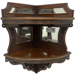 Edwardian carved oak corner wall shelf, quarter round form, fitted with mirror panels, carved with trailing oak leaves and acorns 