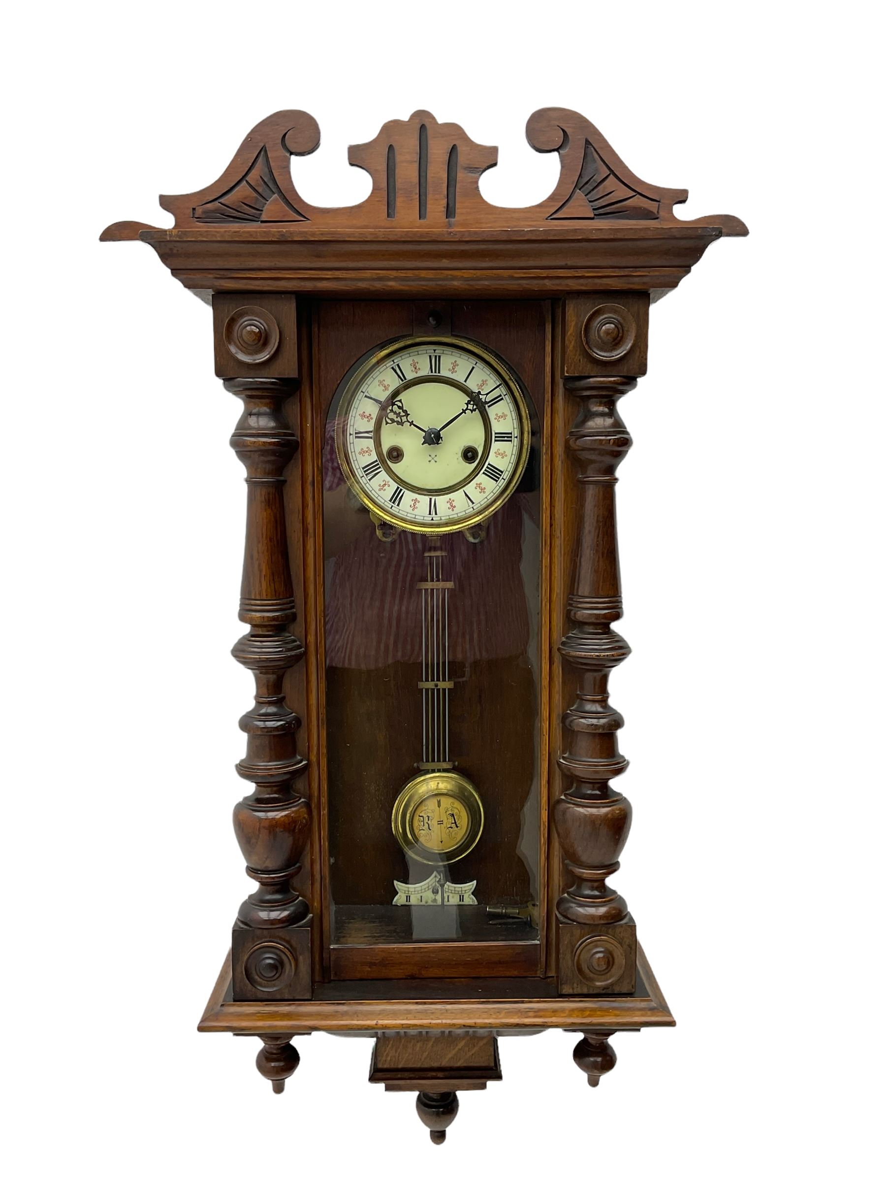 Small Spring driven German wall clock in a mahogany case with turned
