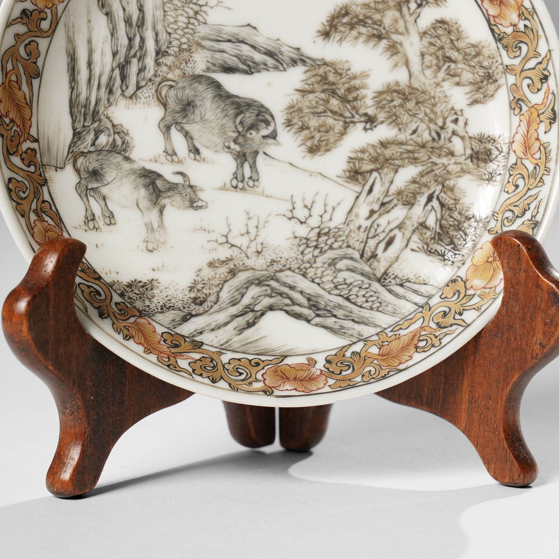Chinese Yongzheng period saucer, finely painted in grisaille with buffalo within a rocky landscape, the inner rim with iron red and gilt foliate band, D11.5cm
