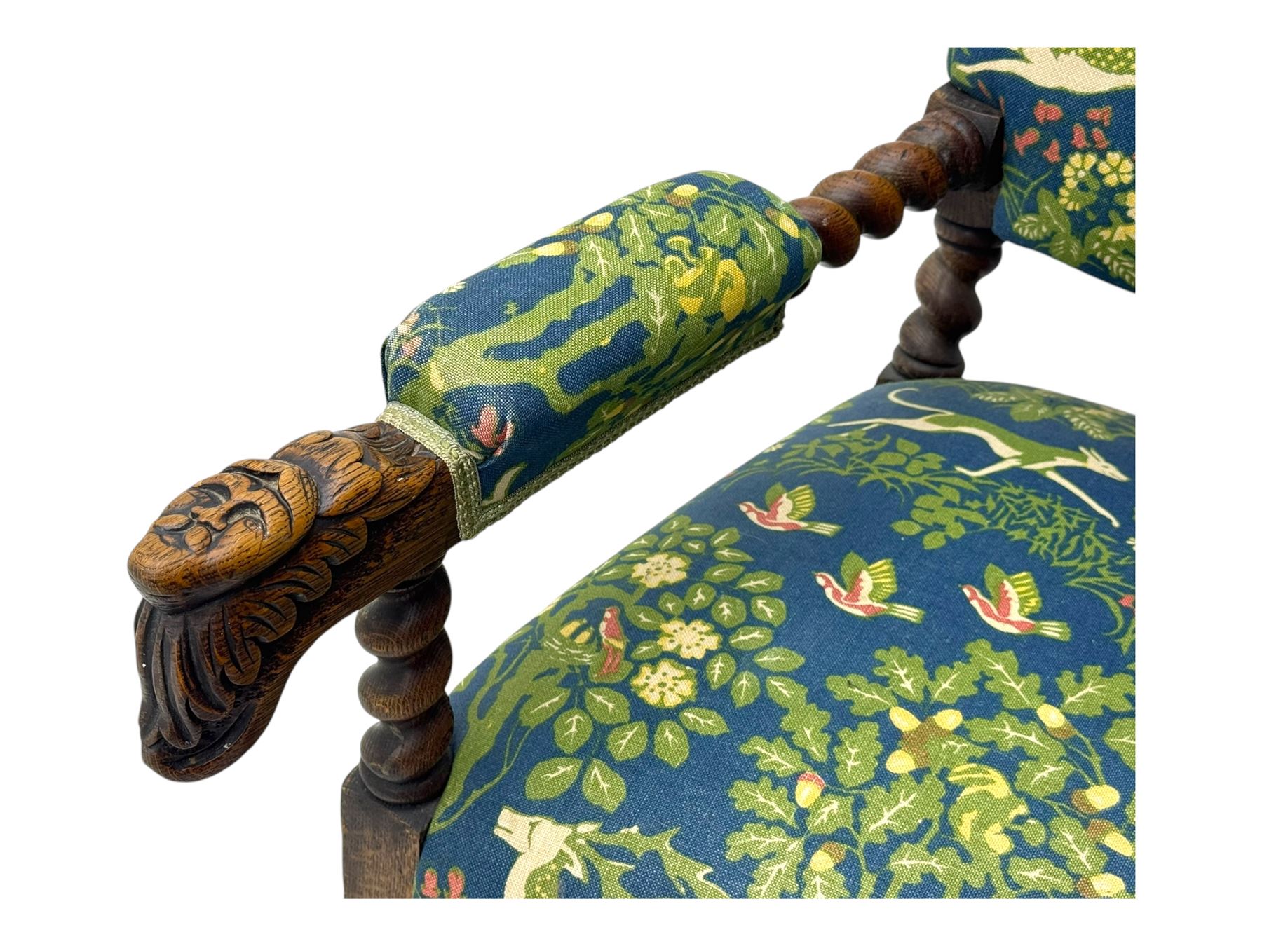 19th century Carolean design oak armchair, upholstered in a vibrant fabric depicting woodland and wildlife scenes, carved lion mask arm terminals, raised on barley twist supports united by H-stretcher