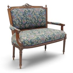 20th century French Louis XVI style stained beech two-seat salon settee, rectangular upholstered back and seat in floral tapestry fabric, carved and moulded frame with foliate cresting, padded open arms and fluted tapering supports