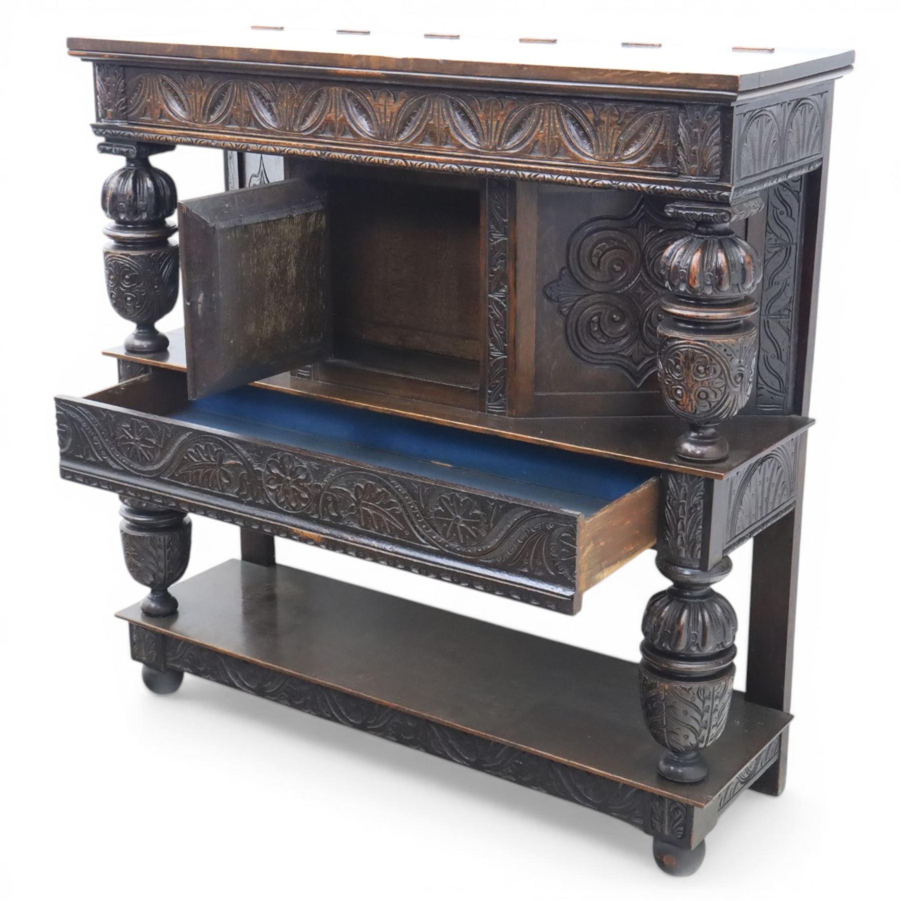 Jacobean revival oak side cabinet, rectangular top above carved frieze of stylised foliage and lunettes, fitted with a central cupboard doors with applied carved panels, above a frieze drawer, supported on turned and carved vase-shaped supports, united by stretcher tier and lower shelf
