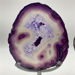 Pair of purple agate slices, polished with rough edges raised upon silvered metal stands, H23cm