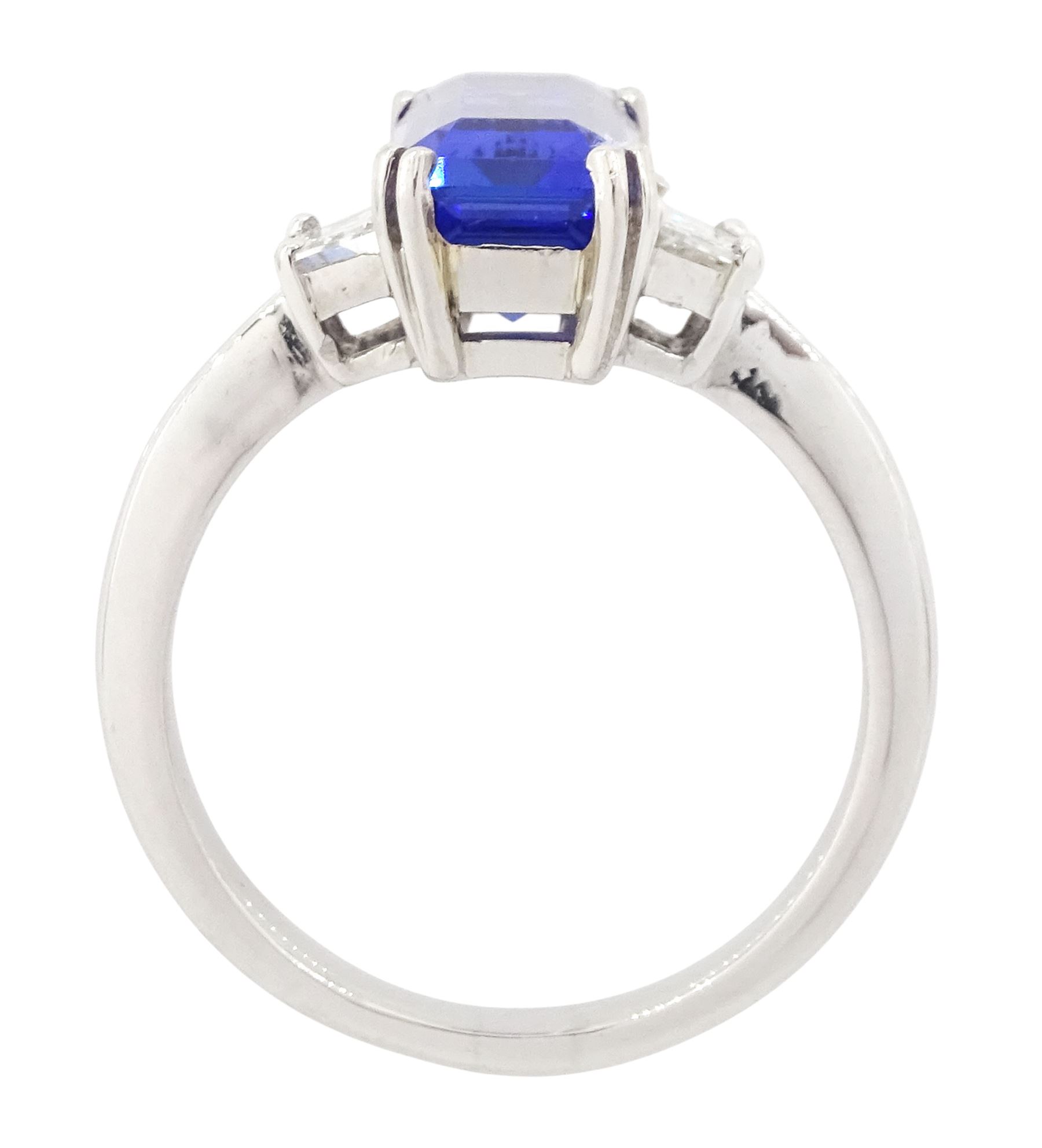 Platinum tanzanite and diamond three stone ring, single emerald cut tanzanite of approx 4.20 carat, with with a single trapeze cut diamond set either side, stamped PT950, total diamond weight approx 0.49 carat, with Alan Poultney Gems report