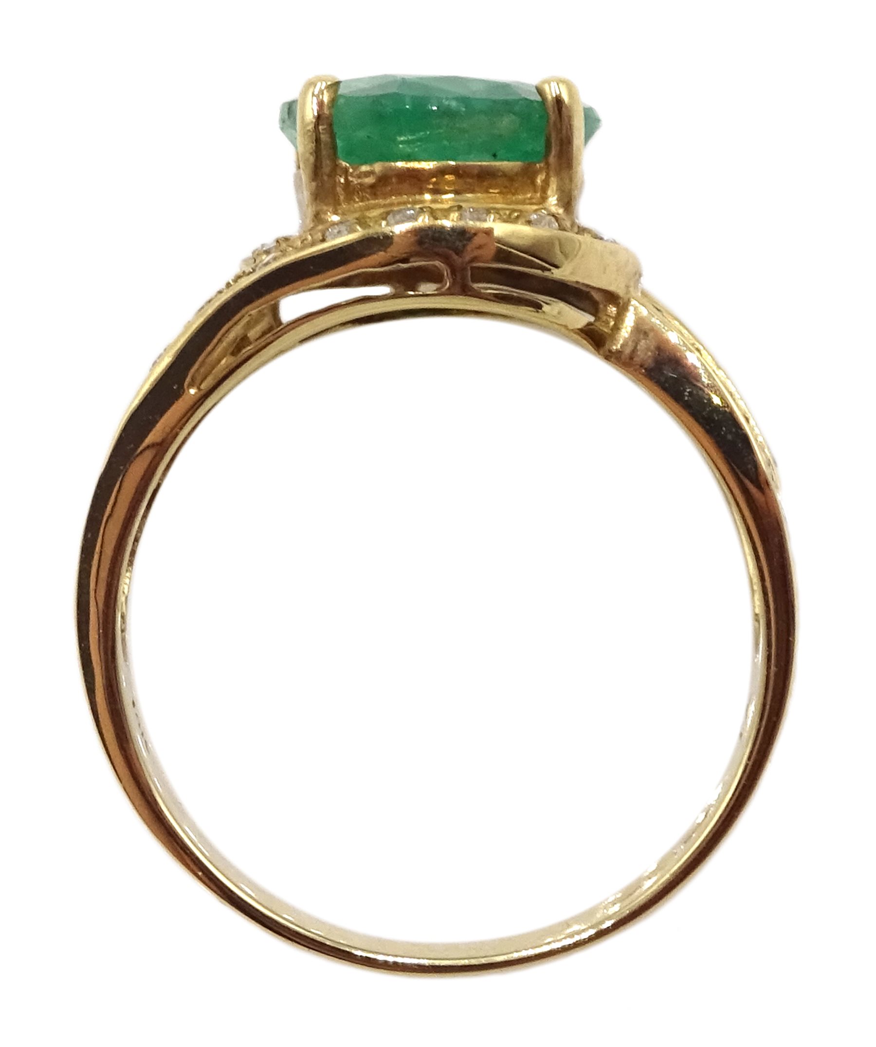 Gold oval emerald ring with diamond swirl surround and shank, stamped 14K