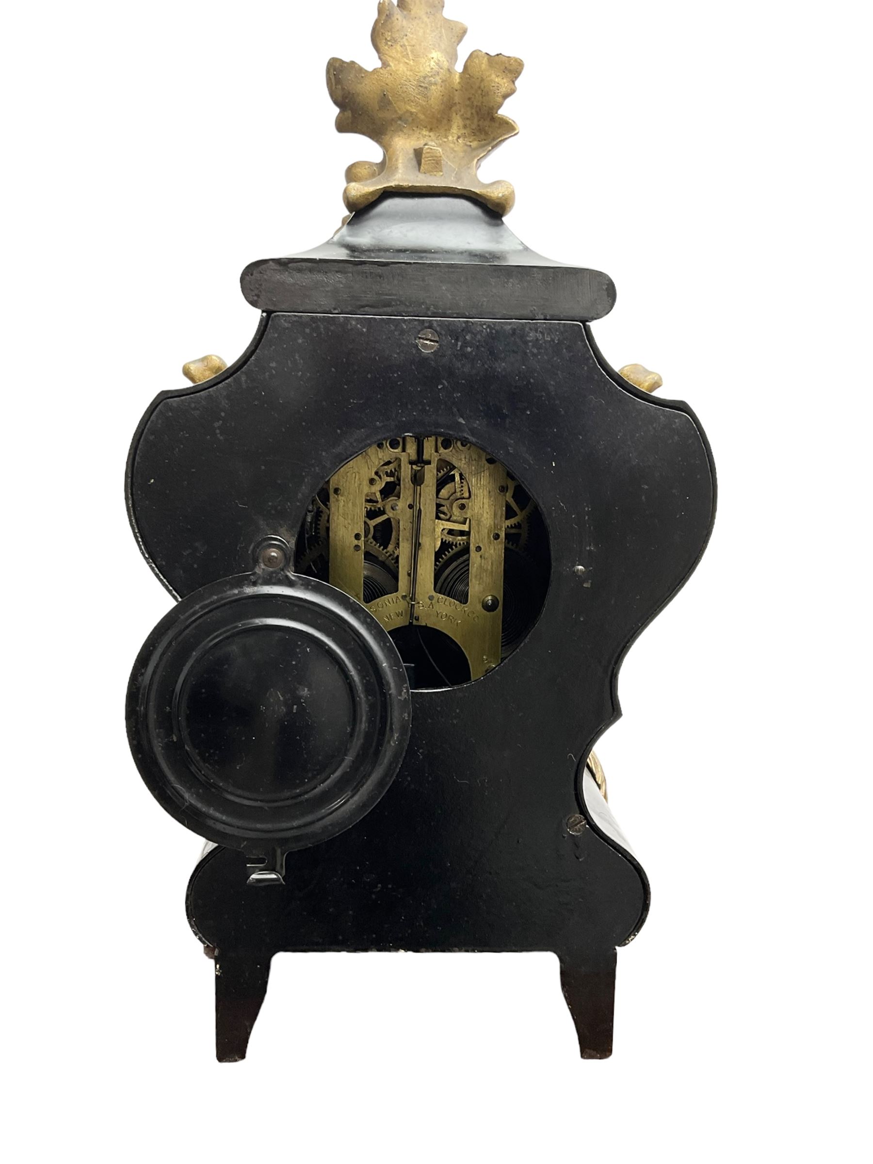 Ansonia - American late 19th century steel cased 8-day mantle clock in a Rococo case with decorative brass mounts, brass dial with Arabic numerals, steel hands and a repousse dial centre, twin train striking movement sounding the hours and half hours on a gong. with pendulum and key.