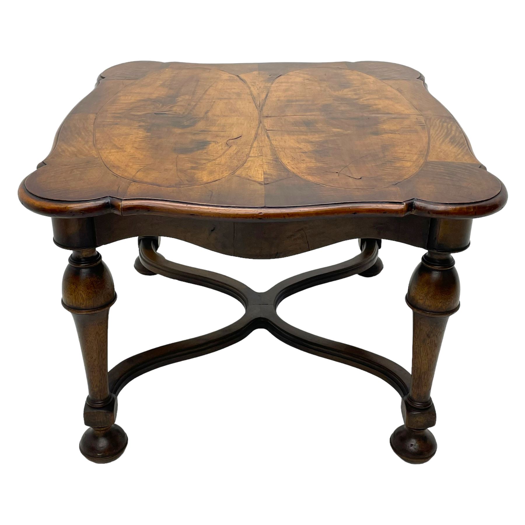 Figured mahogany coffee table, shaped moulded top with oval book-matched veneered panels, on turned supports united by waved X-shaped stretchers 
