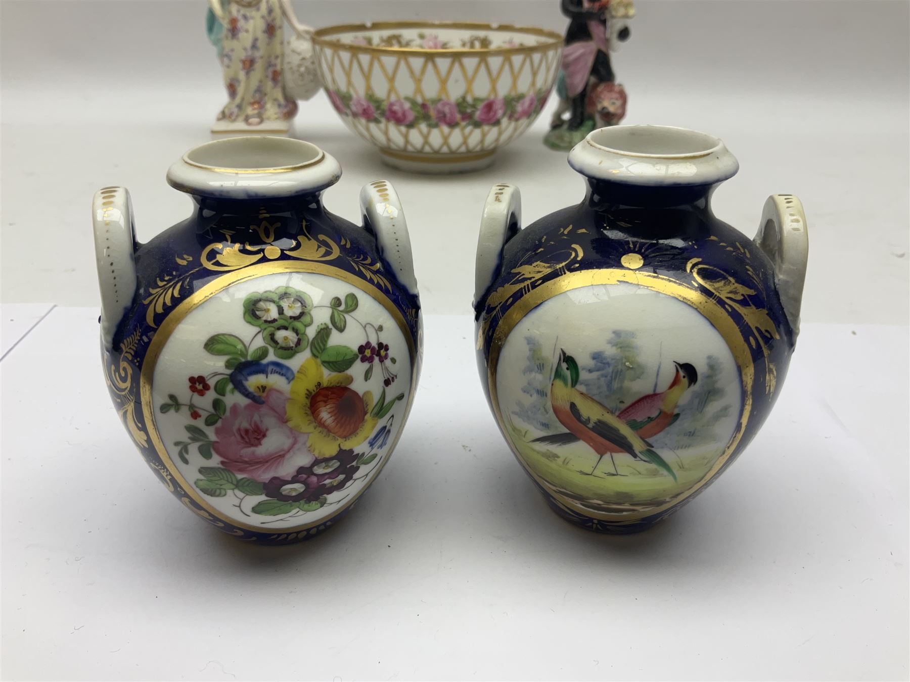 Group of 18th and 19th century ceramics for repair and restoration, to include an 18th century Derby figure emblematic of the Continent of Africa, pair of small 19th century Derby vases, painted with birds and floral spray, 19th century Derby slop bowl decorated in the 594 pattern with pink roses against gilt trellis, 19th century Derby figure of a recumbent deer, Serves style box, and two further figures