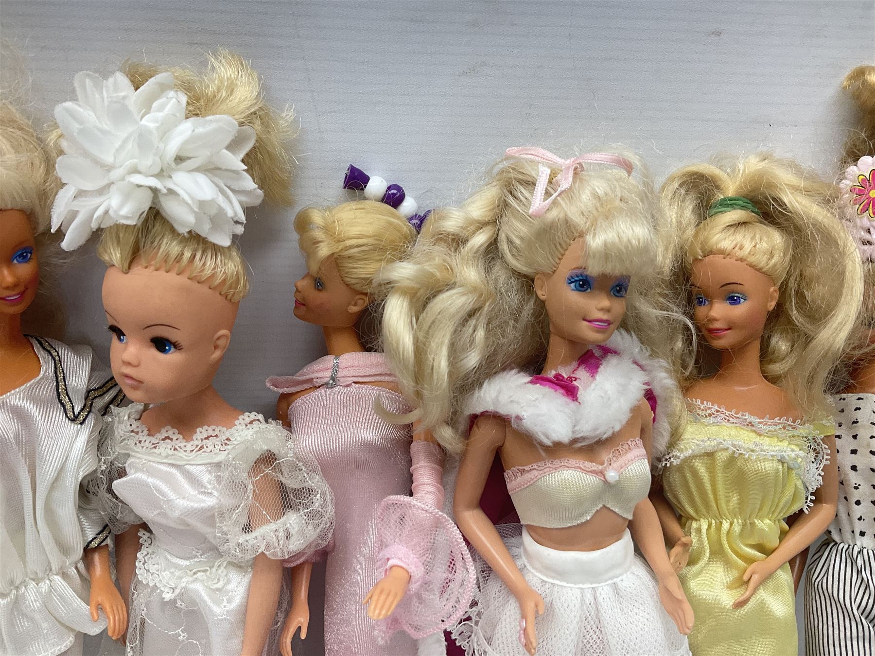 Eleven 1980s fashion dolls, predominantly Barbie/Ken, all dressed; together with some additional clothing.
