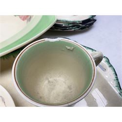 Clarice Cliff for Newport Pottery Corolla pattern tea and dinner wares, comprising triangular bowl, four side plates, two shallow bowls and teacup (a/f), together with a Clarice Cliff Wilkinson twin handled soup bowl and unassociated saucer both decorated with pink and yellow flowers, together with other mid century ceramics comprising Parrott and Company Coronet Ware, and Royal Staffordshire AJ. Wilkinson Ltd dinner wares