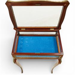 Early 20th century French mahogany bijouterie table, the hinged shaped rectangular top with brass edge and gilt-metal foliate slip enclosing bevelled glass plate, raised on cabriole supports with applied gilt-metal cartouche and foliate mounts