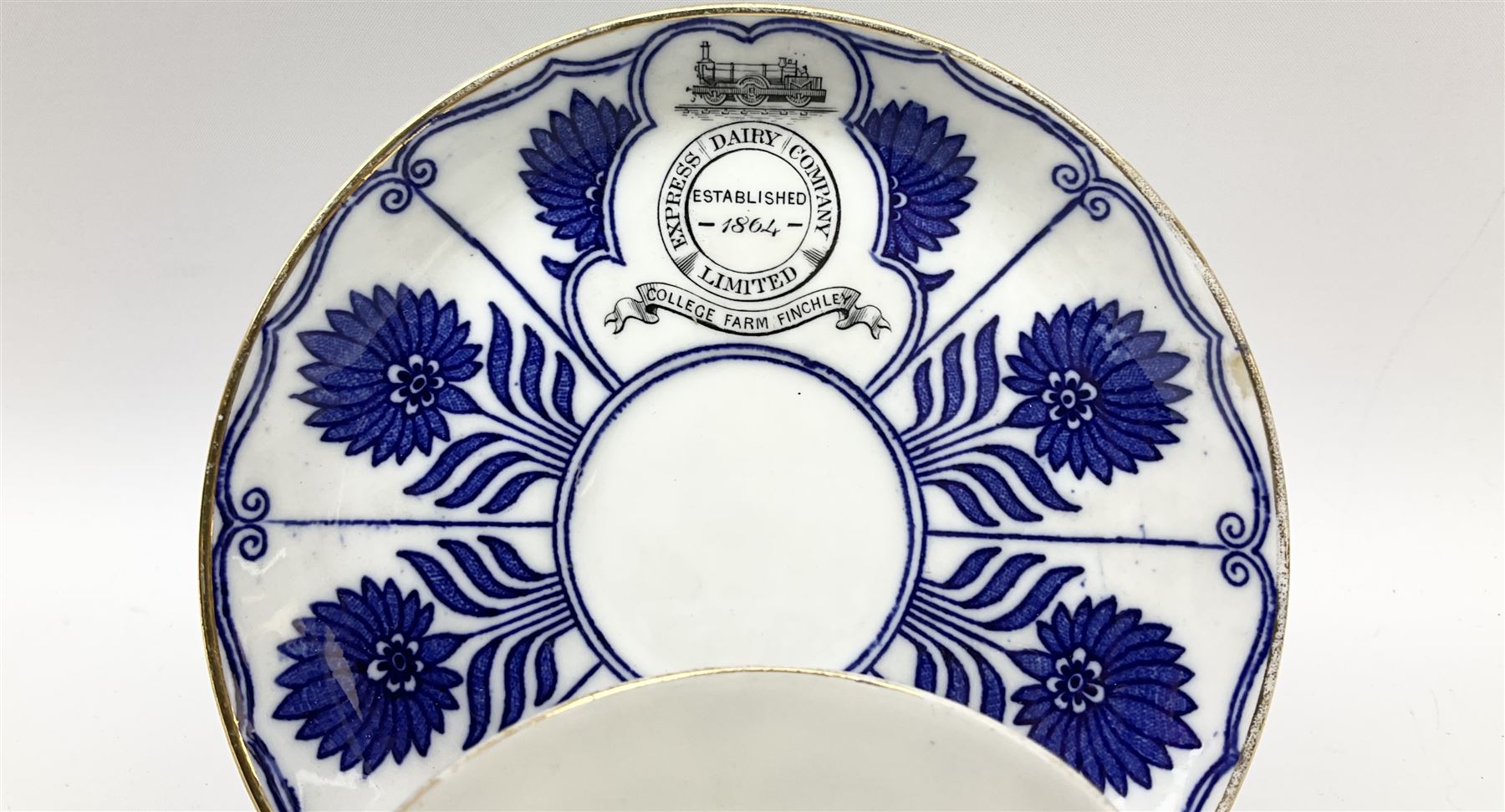 Late 19th century Coalport porcelain cup and saucer in the 'Aster' pattern bearing the crest of Express Dairy Company Limited, College Farm, Finchley and decorated with a steam locomotive