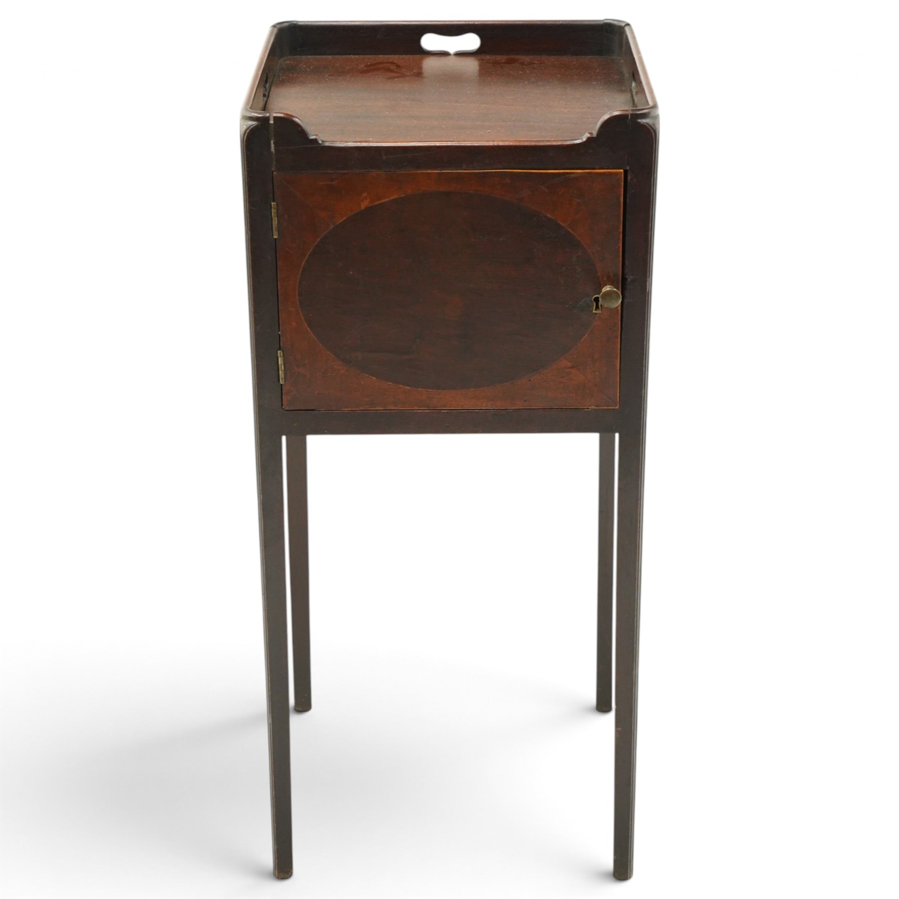 George III mahogany bedside pot cupboard, rectangular tray top with raised three-quarter gallery with pierced handles, fitted with single cross-banded cupboard, on square tapering supports
