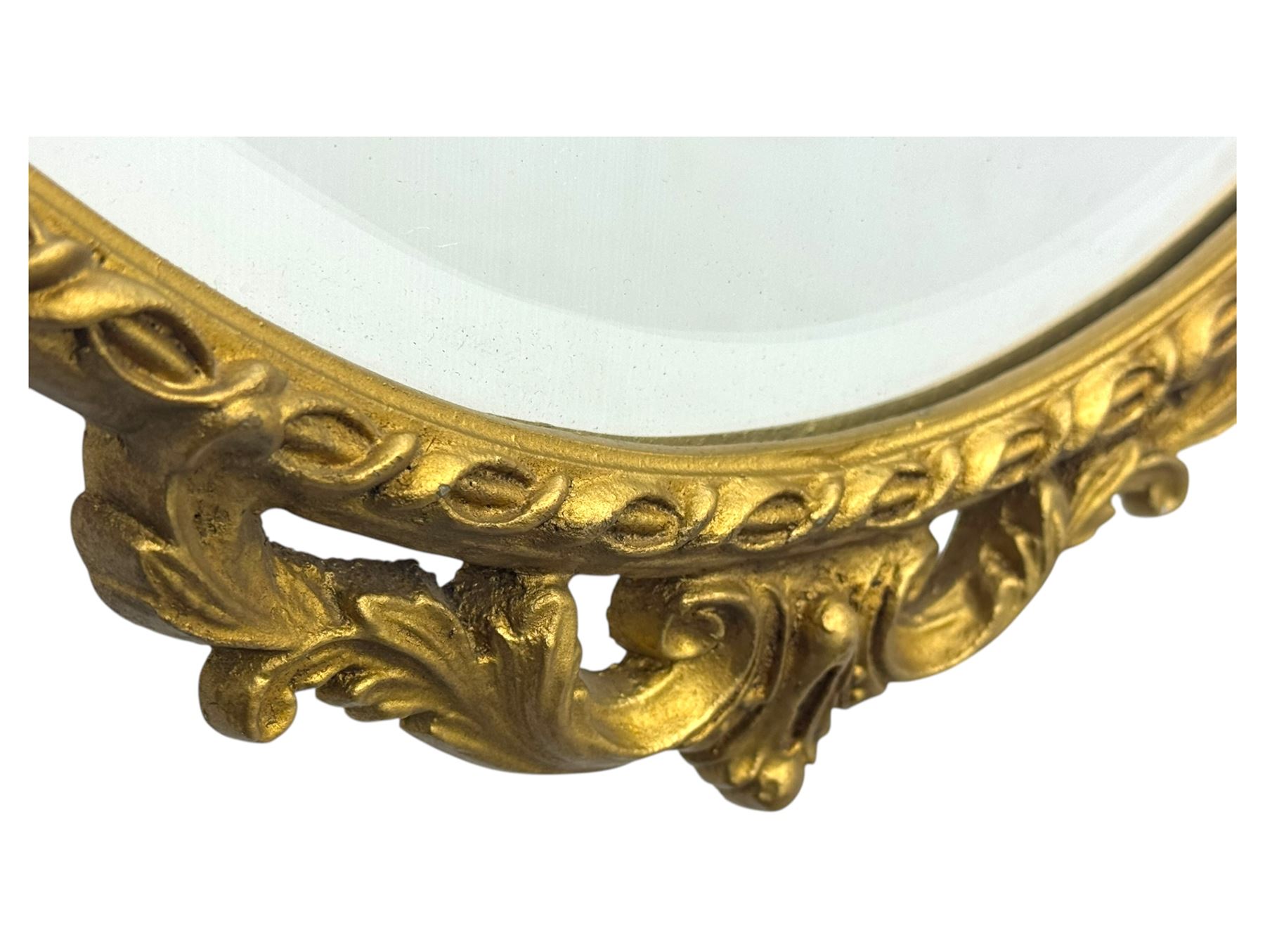 Oval gilt wall mirror, with bevelled edge plate within a moulded frame cast with acanthus scrolls and foliate decoration, pierced cartouche crest and apron, flanked by scrollwork handles