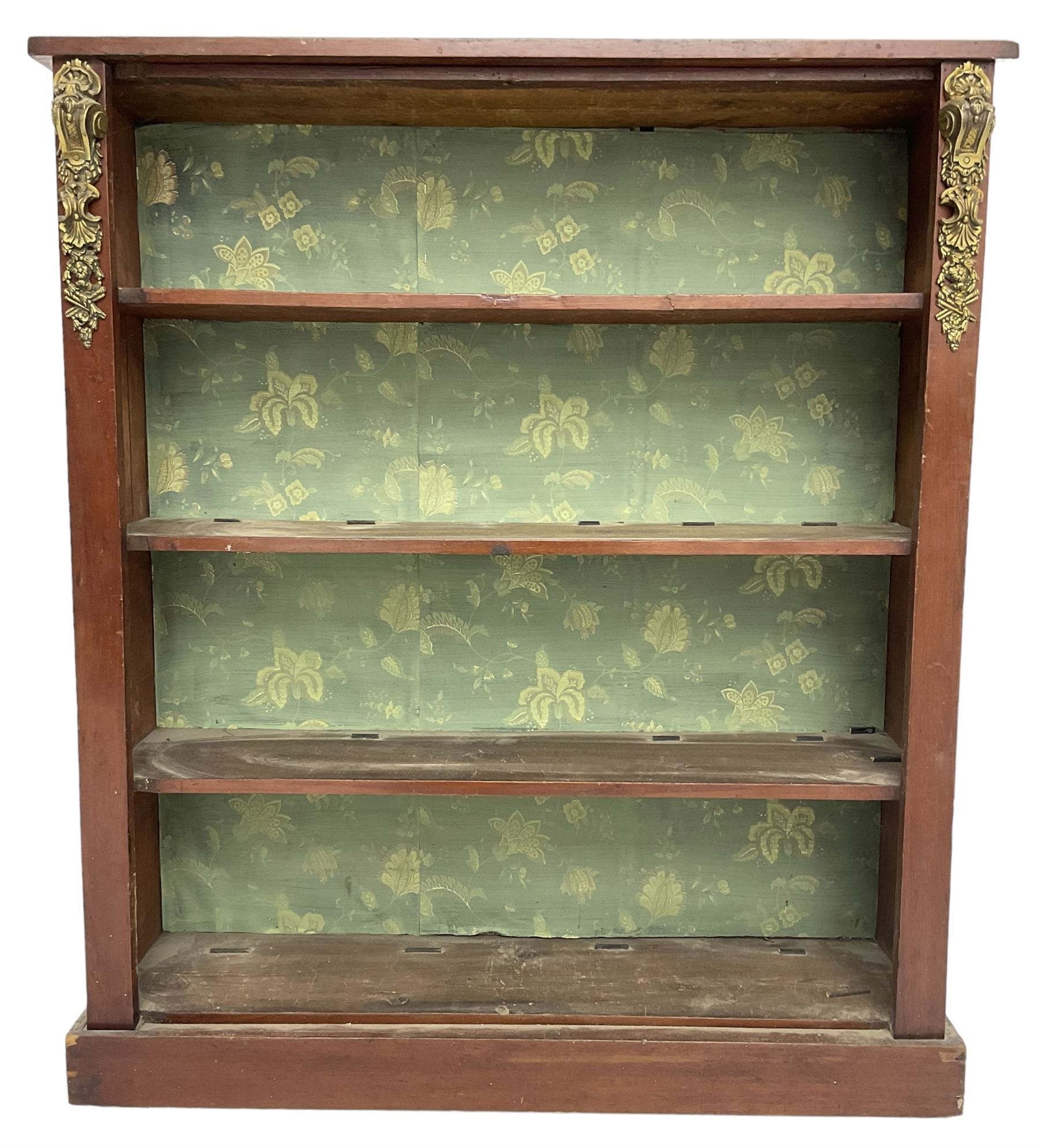 Early 20th century mahogany open bookcase, fitted with three shelves on plinth base, decorated with foliate patterned gilt metal mounts