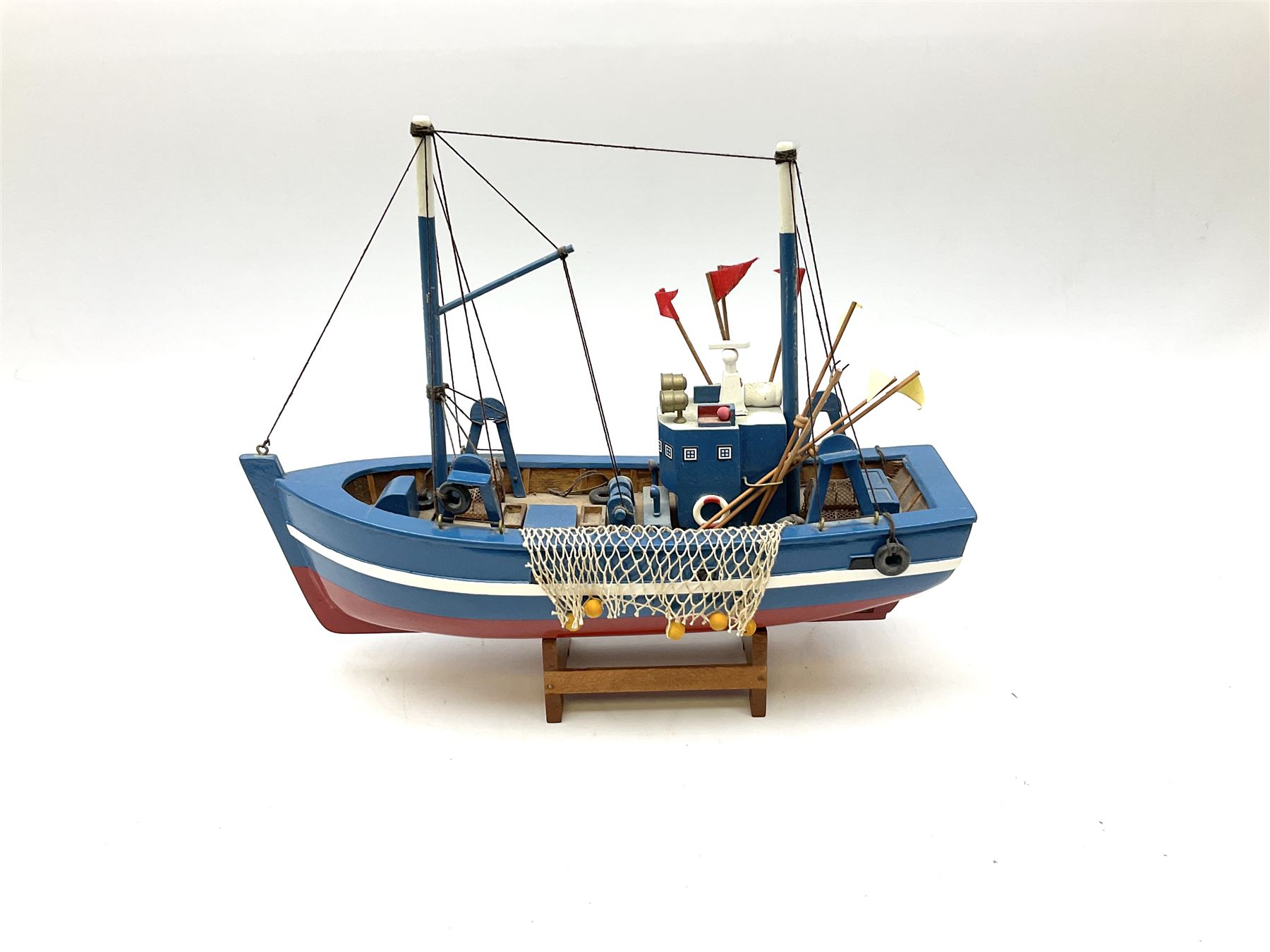 Wooden model of RMS Titanic, on a fixed black stand bearing plaque inscribed 'Titanic 1912', L54cm, H22cm, together with model of a sloop, gaff rigged on stand bearing plaque inscribed 'Sloop' L32cm, H42cm; and model of a fishing trawler on a stand bearing plaque inscribed 'Chalutier' L35cm, H28cm (3)