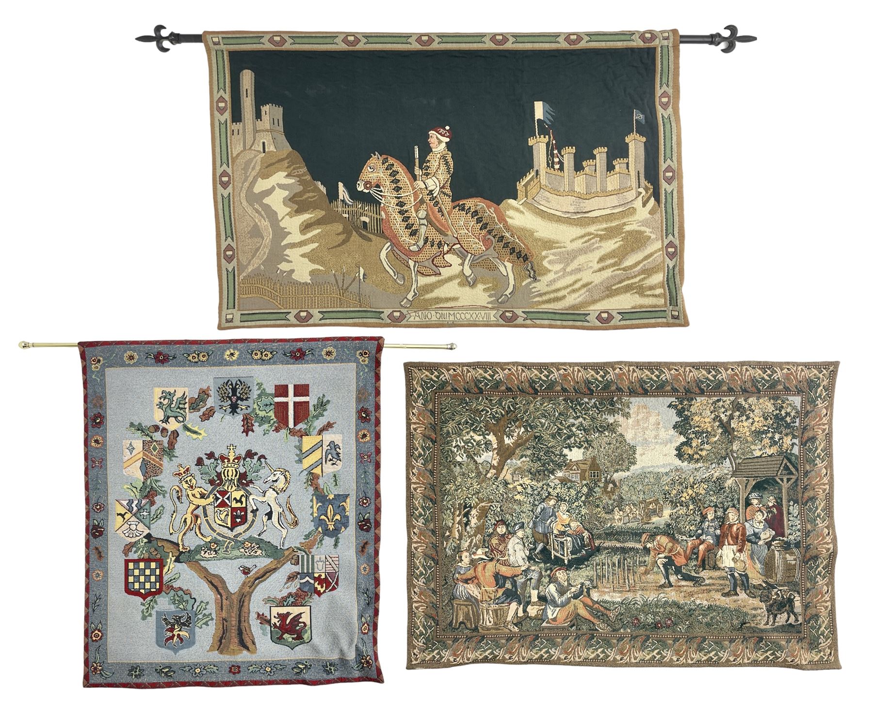 Three tapestries comprising 20th century wool tapestry panel of a medieval nobleman upon a horse with a castle in the distance, together with a smaller tapestry depicting The English Coat of Arms, both hung on rails, and further depicting village scene, largest approx 132cm x 95cm