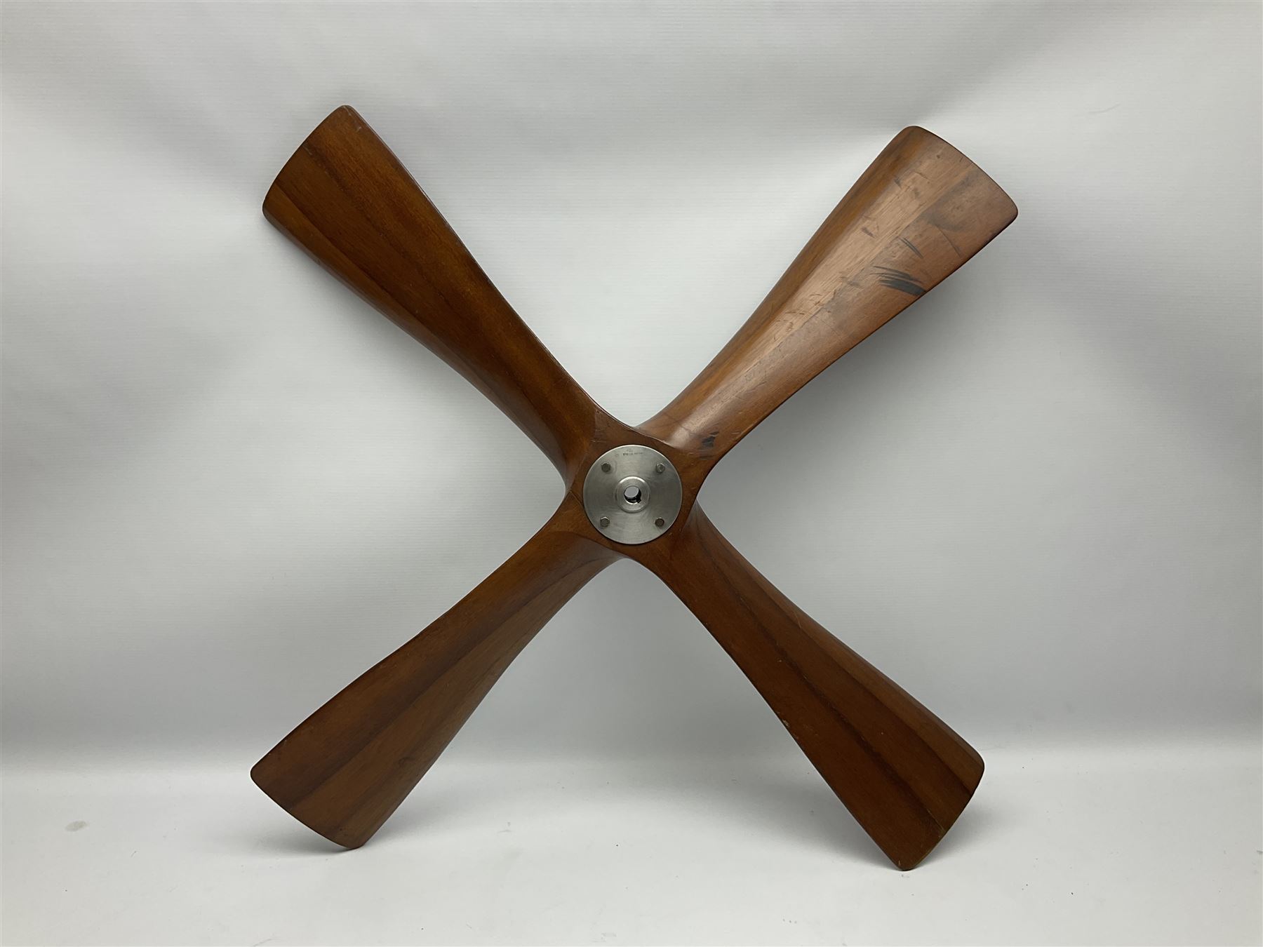 British World War II era laminated wooden four-bladed generator propeller, late 1930s-40s, used to power a drogue winch used by a target tug aircraft; marked with DRG drawing number T29505-2-4 N760 on the hub and impressed circle mark 'P.M.P.W. 1'; light weight four plank mahogany laminate with 9.5cm diameter metal plates mounted to front and rear faces of hub for 15mm shaft; one plate marked T29504-2/198 D91cm; together with a modern reproduction brass edged mahogany two-blade propellor L