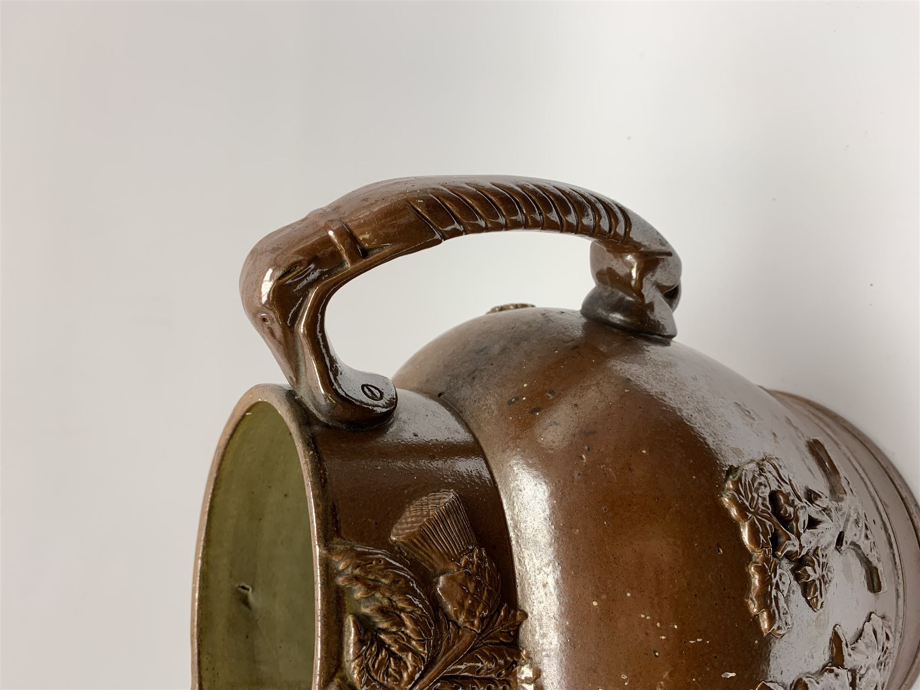 19th century salt glazed stoneware jug, with mask spout and greyhound modelled handle, the body decorated in relief with Royal Coat of Arms flanked by lions, the rim with the flowers of the union, roses, thistles and shamrocks, H26.5cm