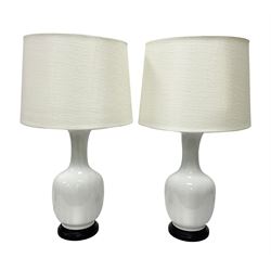 Pair of Chinese ivory crackle glazed table lamps, each of bottle form, raised upon circular hardwood base, excluding fittings H43cm
