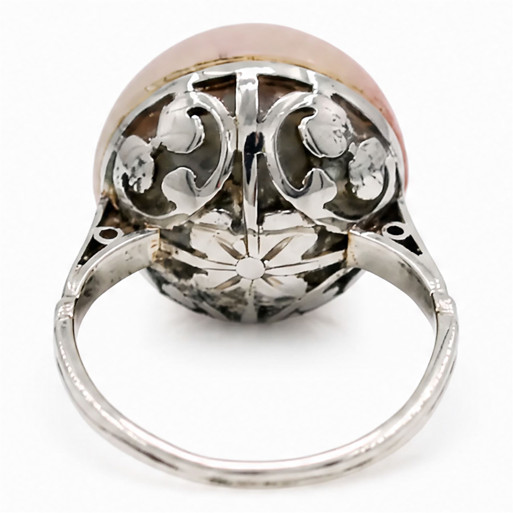 Early 20th century 18ct white gold pink mabe pearl ring, with pierced design floral and scroll gallery