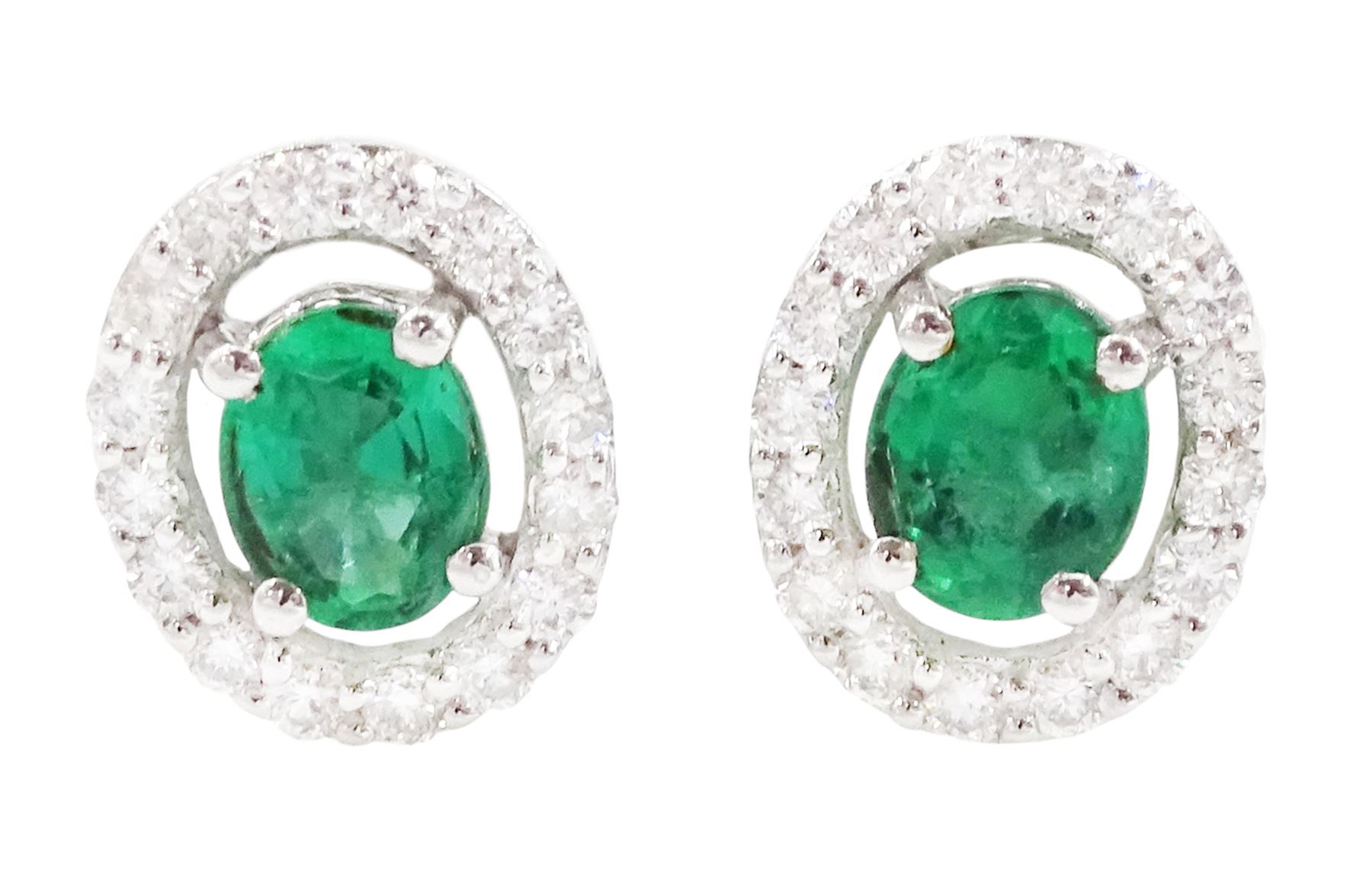 Pair of 18ct white gold emerald and diamond cluster earrings, each stud set with a single oval cut emerald, surrounded by a halo of round brilliant cut diamonds, stamped 750, total emerald weight approx 0.80 carat, total diamond weight approx 0.15 carat